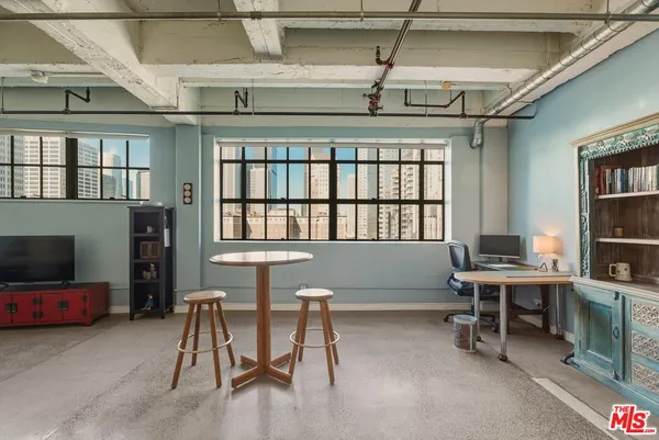 a view of a livingroom with workspace and a window