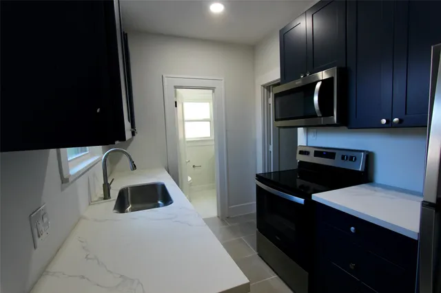 a kitchen with a sink stove and microwave