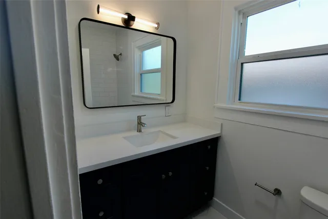 a bathroom with a toilet sink and mirror
