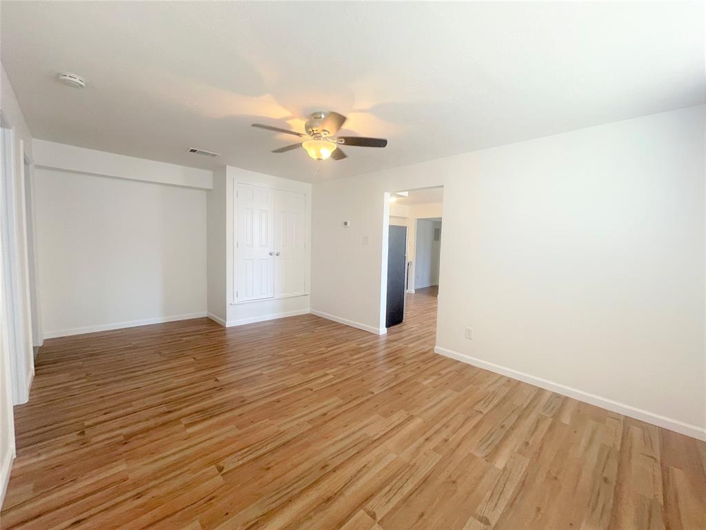 2309 Wesley Street, Unit B Greenville, TX 75401 - Photo 11 of 27 an empty room with wooden floor and ceiling fan