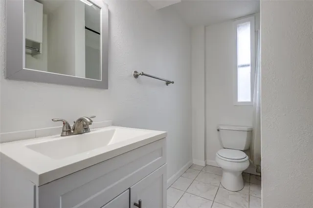 a bathroom with a sink toilet and mirror