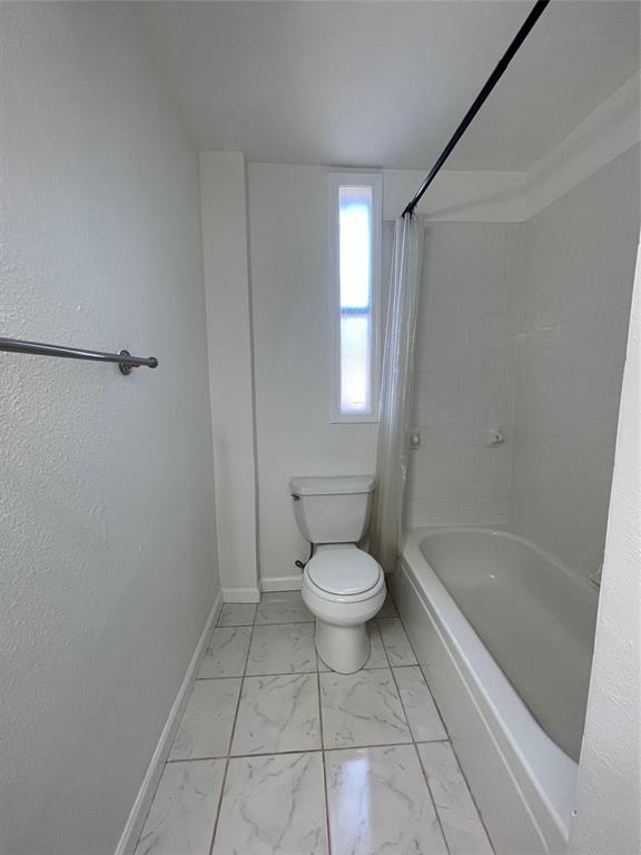 2309 Wesley Street, Unit B Greenville, TX 75401 - Photo 17 of 27 a bathroom with a toilet and a shower