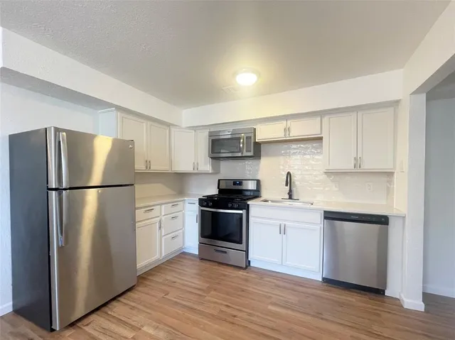 a kitchen with stainless steel appliances a refrigerator and cabinets