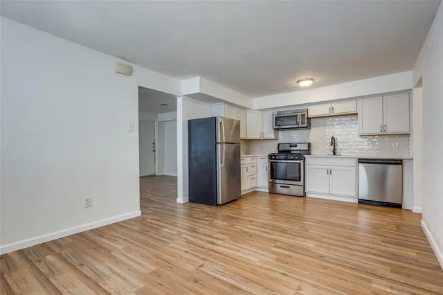 a kitchen with a sink a refrigerator and a stove top oven