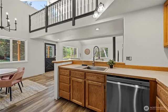 a kitchen with stainless steel appliances granite countertop a sink and wooden floors