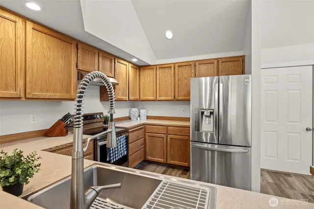 a kitchen with stainless steel appliances a refrigerator sink and cabinets