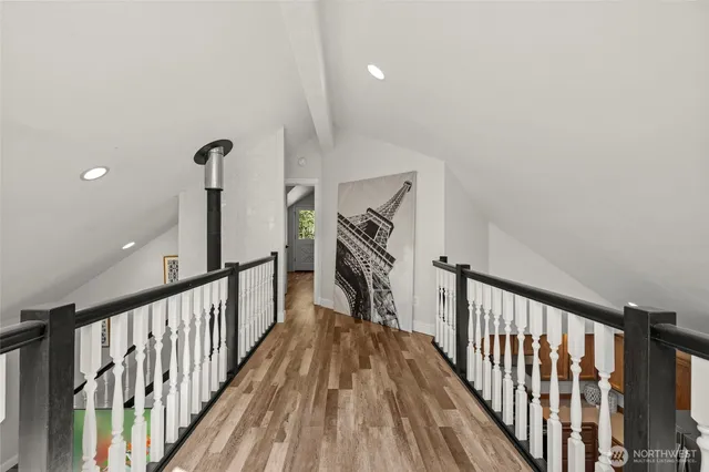a view of a hallway with wooden floor and stairs