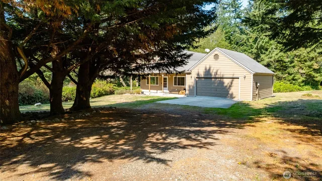 a view of a yard in front of a house with large trees