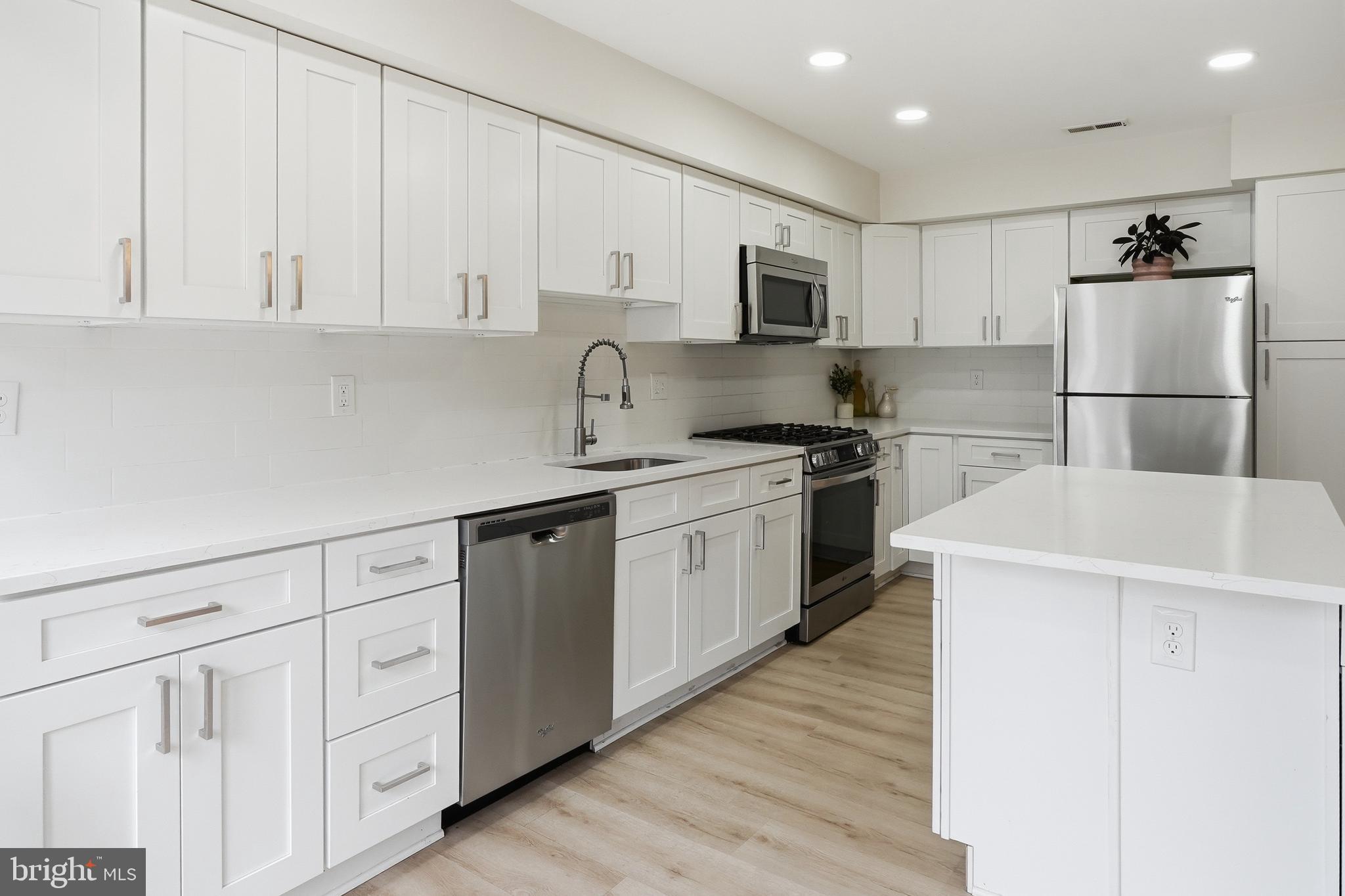 6524 Milva Lane Springfield, VA 22150 - Photo 14 of 47 a kitchen with white cabinets sink and white appliances