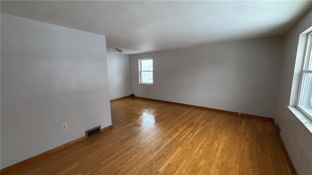 22 Adrian Avenue, Unit 2 Pittsburgh, PA 15229 - Photo 5 of 14 an empty room with wooden floor and windows