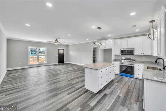 a bedroom with a large bed a chandelier and dresser