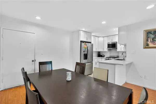 a kitchen with stainless steel appliances granite countertop a sink a stove a refrigerator a microwave oven with a dining table and chairs