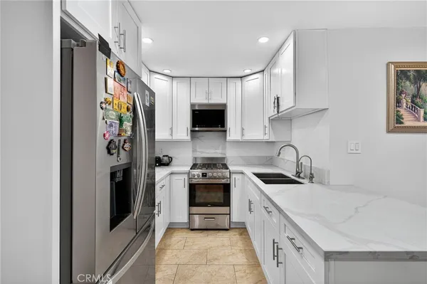 a kitchen with stainless steel appliances granite countertop a sink stove and refrigerator
