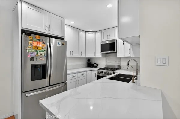 a kitchen with stainless steel appliances a refrigerator stove microwave and sink