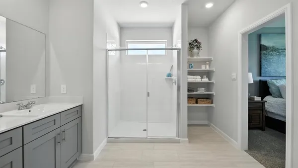 a bedroom with a bed and a large mirror on the dresser
