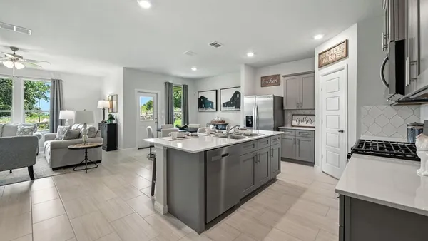 a kitchen with kitchen island a stove a table and chairs