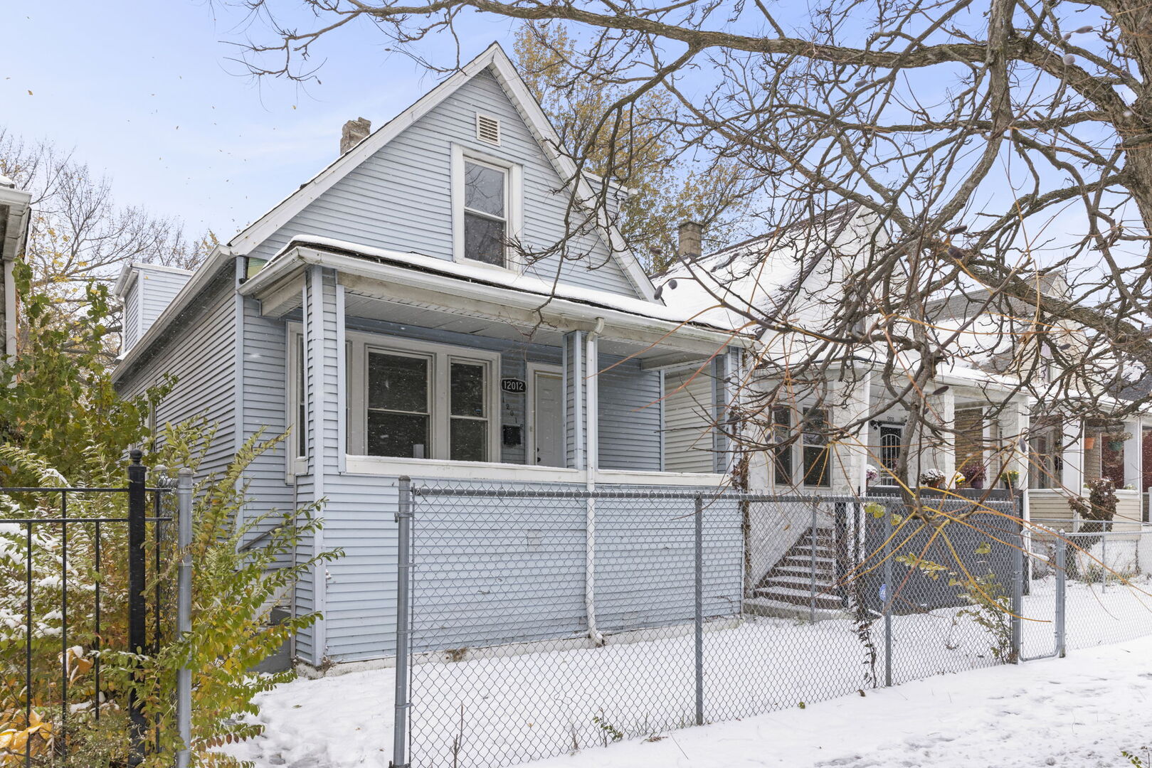 a view of a white house with a large tree