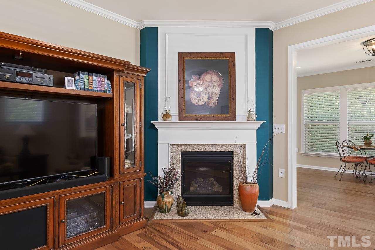 613 Tuttle Road Durham, NC 27703 - Photo 6 of 30 Natural gas fireplace in family room leading to sunroom.