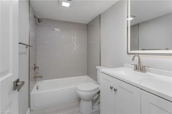 a bathroom with a granite countertop sink a toilet and shower