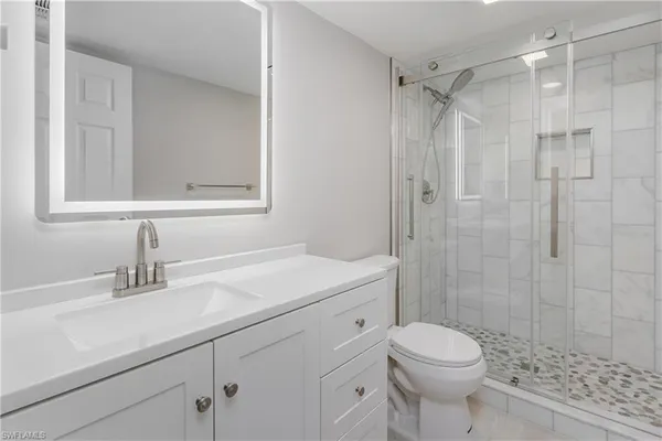 a bathroom with a sink a toilet and shower