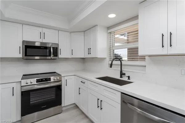a kitchen with white cabinets and stainless steel appliances