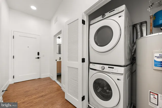 a view of a hallway with wooden floor and cabinet
