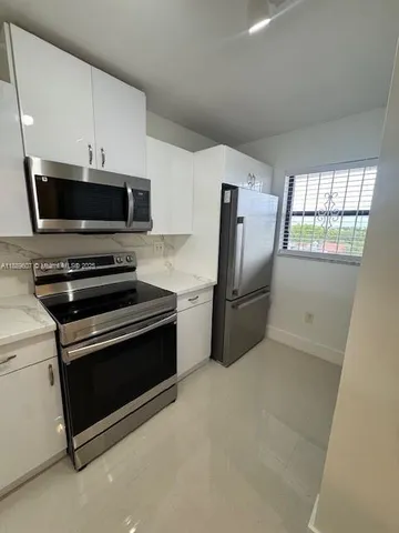 a kitchen with stainless steel appliances a stove a microwave and a refrigerator