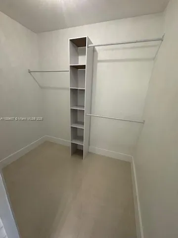 a view of walk in closet with empty racks