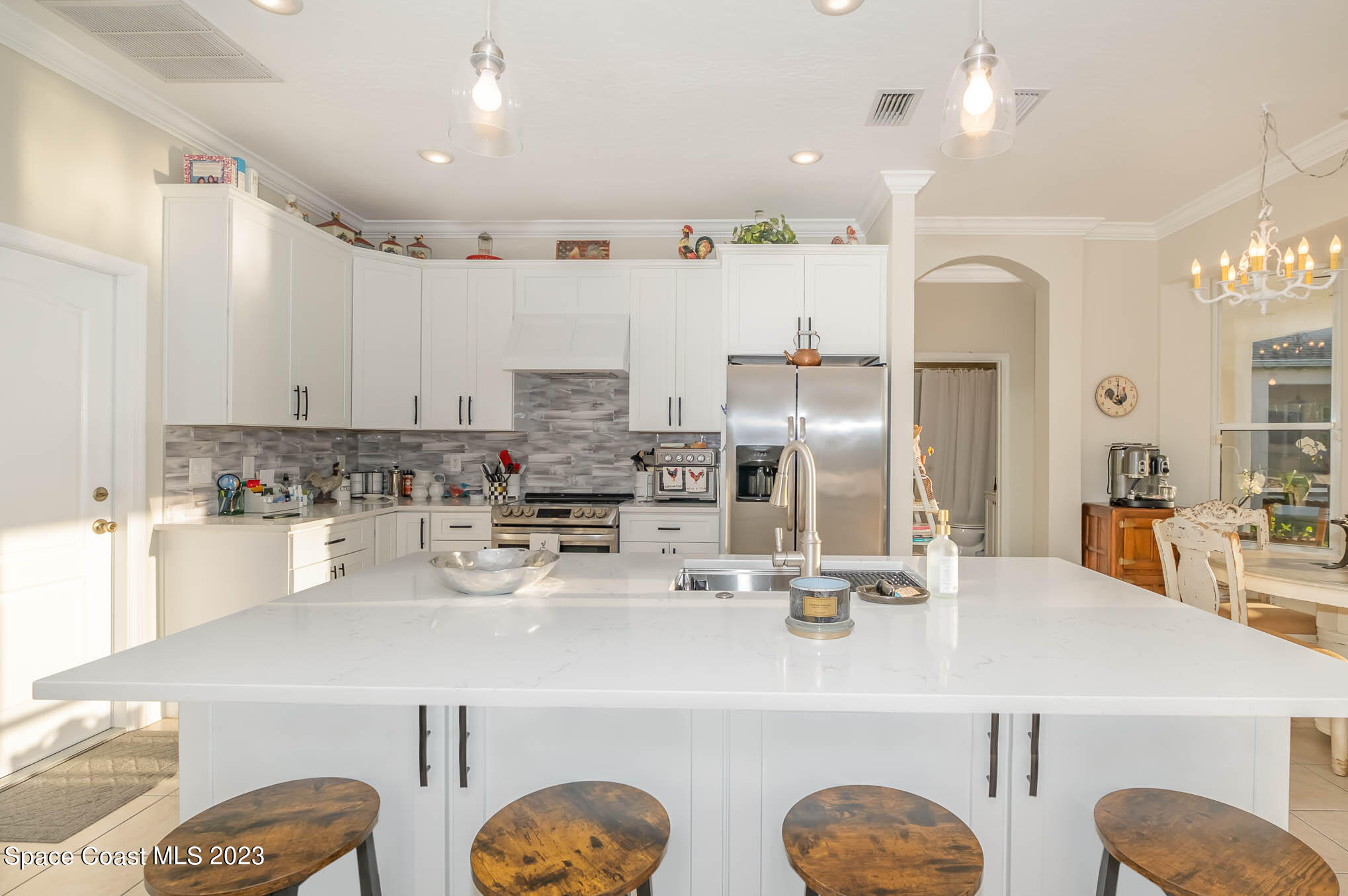 3032 Jacobaeus Lane Indialantic, FL 32903 - Photo 14 of 43 a kitchen with kitchen island granite countertop a sink a stove and chairs