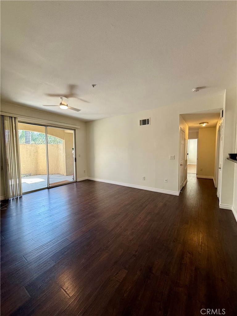 375 Central Avenue, Unit 113 Riverside, CA 92507 - Photo 2 of 19 an empty room with wooden floor and windows