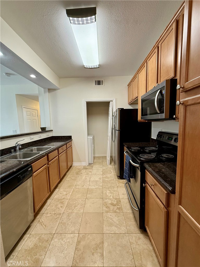 375 Central Avenue, Unit 113 Riverside, CA 92507 - Photo 5 of 19 a kitchen with stainless steel appliances granite countertop a stove and a sink
