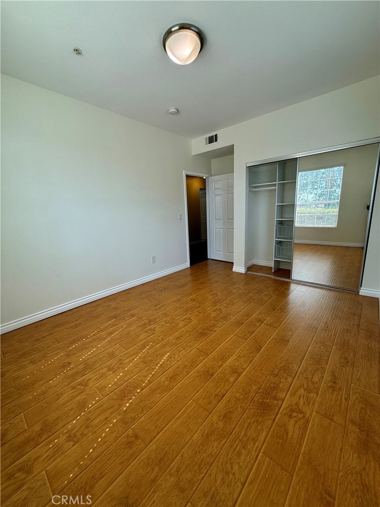 375 Central Avenue, Unit 113 Riverside, CA 92507 - Photo 8 of 19 an empty room with wooden floor and windows