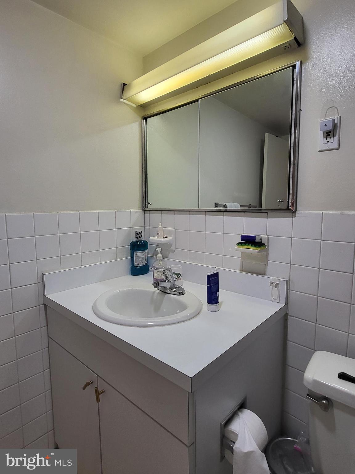 224 West Rittenhouse Square, Unit 413 Philadelphia, PA 19103 - Photo 13 of 25 a bathroom with a sink toilet and mirror