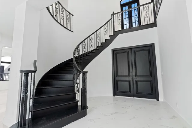 a living room with furniture large windows and wooden floor