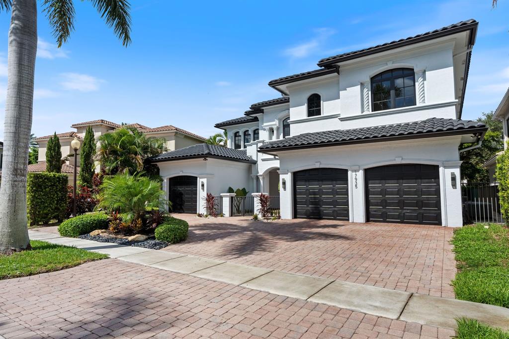 17935 Monte Vista Drive Boca Raton, FL 33496 - Photo 2 of 60 a front view of a house with a garden