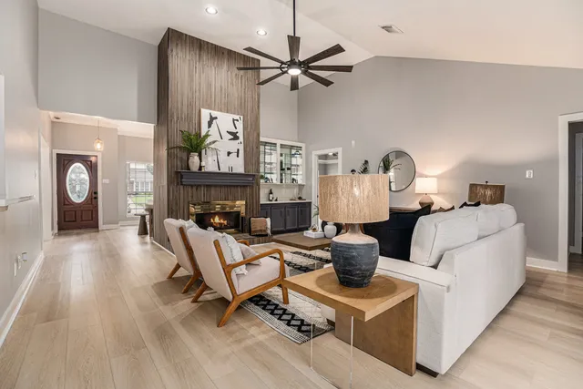 a living room with furniture a fireplace and a chandelier