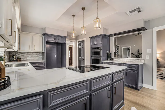 a kitchen with a sink a center island and stainless steel appliances