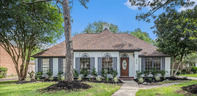 a front view of a house with yard and green space