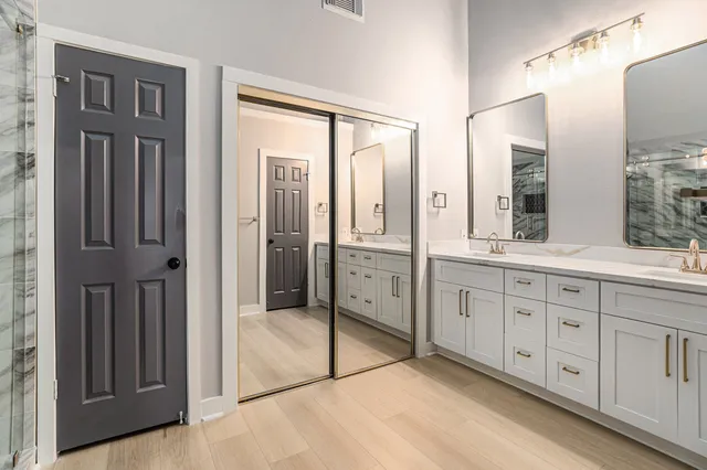 a spacious bathroom with double vanity and mirrors