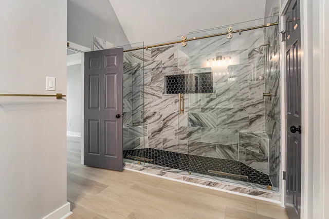 a bathroom with a shower and a glass door