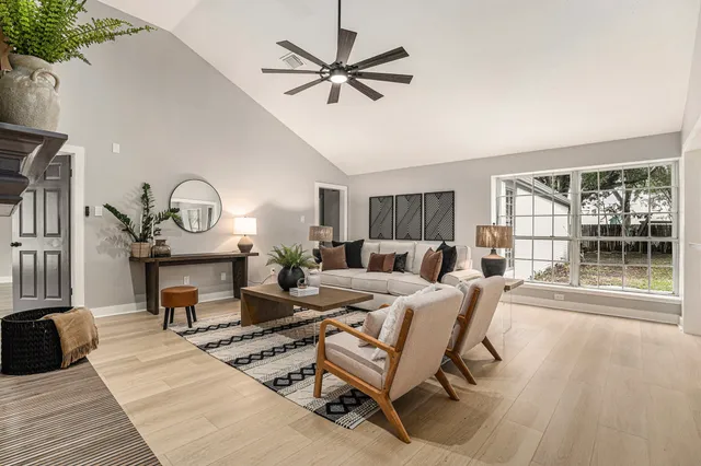 a living room with furniture a fireplace and a floor to ceiling window