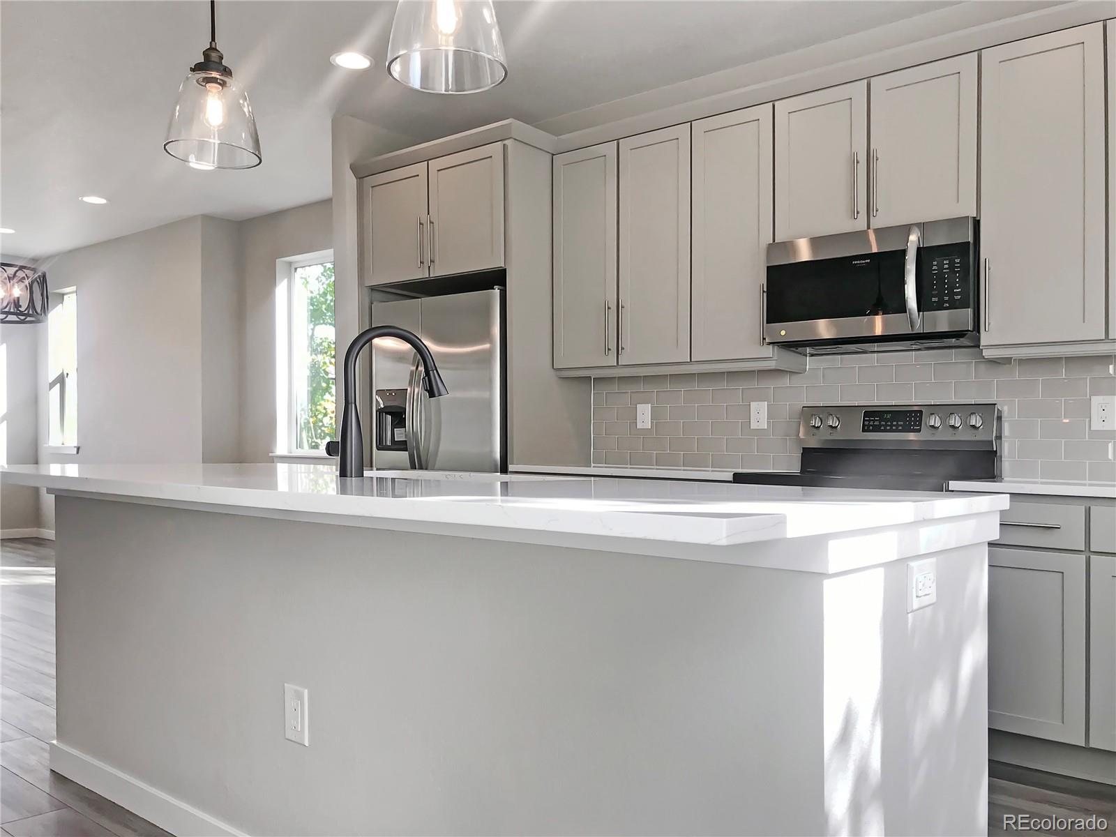 6767 South Tempe Court Aurora, CO 80016 - Photo 11 of 25 a kitchen with stainless steel appliances granite countertop a sink a microwave a refrigerator and cabinets