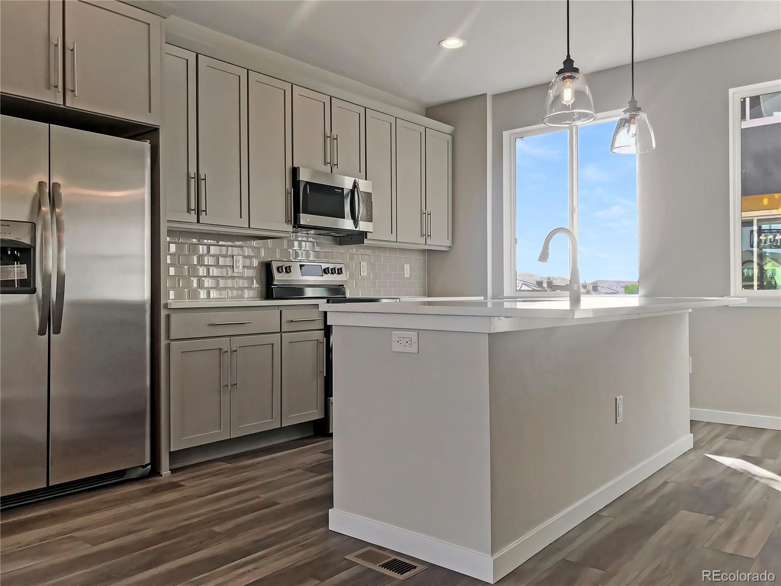 6767 South Tempe Court Aurora, CO 80016 - Photo 13 of 25 a kitchen with kitchen island a sink stainless steel appliances and cabinets