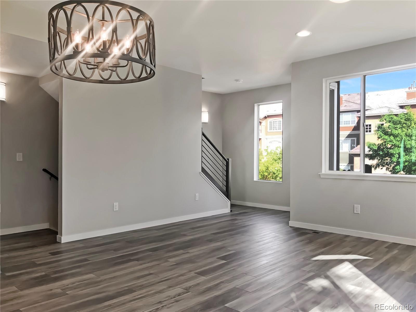 6767 South Tempe Court Aurora, CO 80016 - Photo 15 of 25 an empty room with wooden floor fan and windows