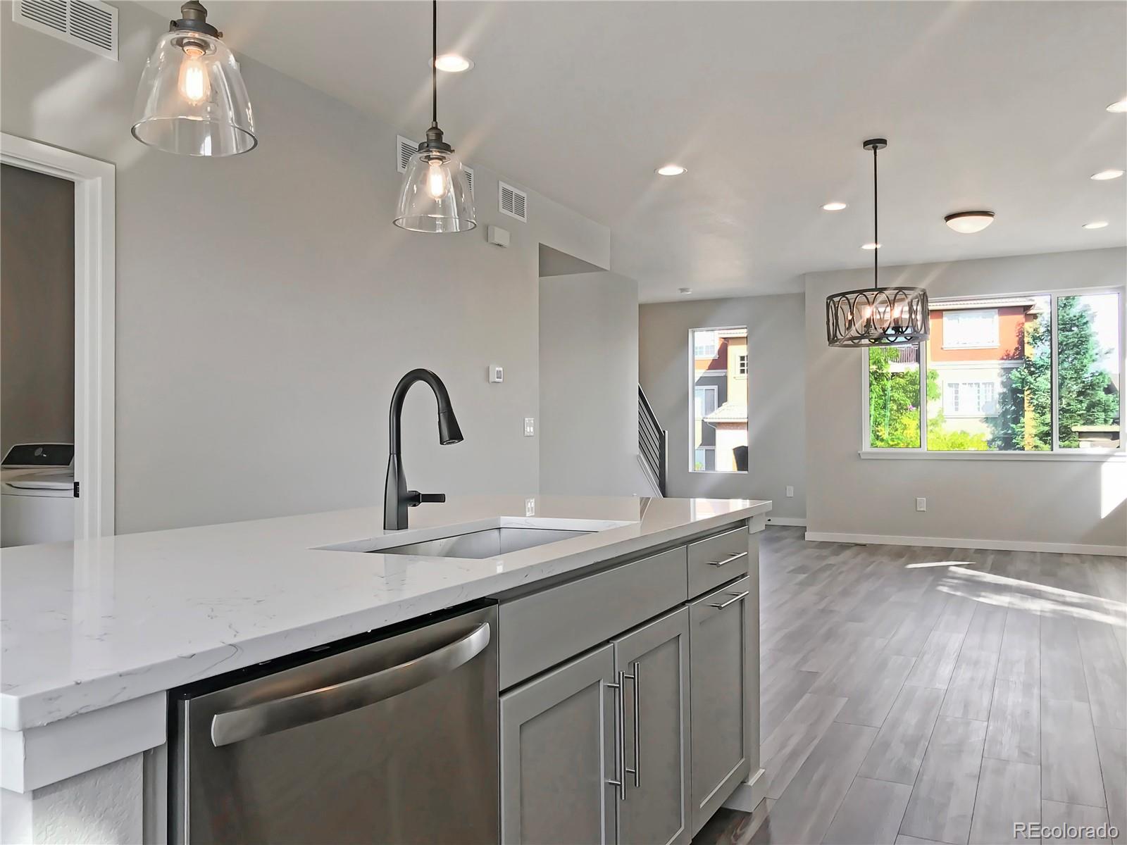 6767 South Tempe Court Aurora, CO 80016 - Photo 4 of 25 a kitchen with a sink cabinets and wooden floor