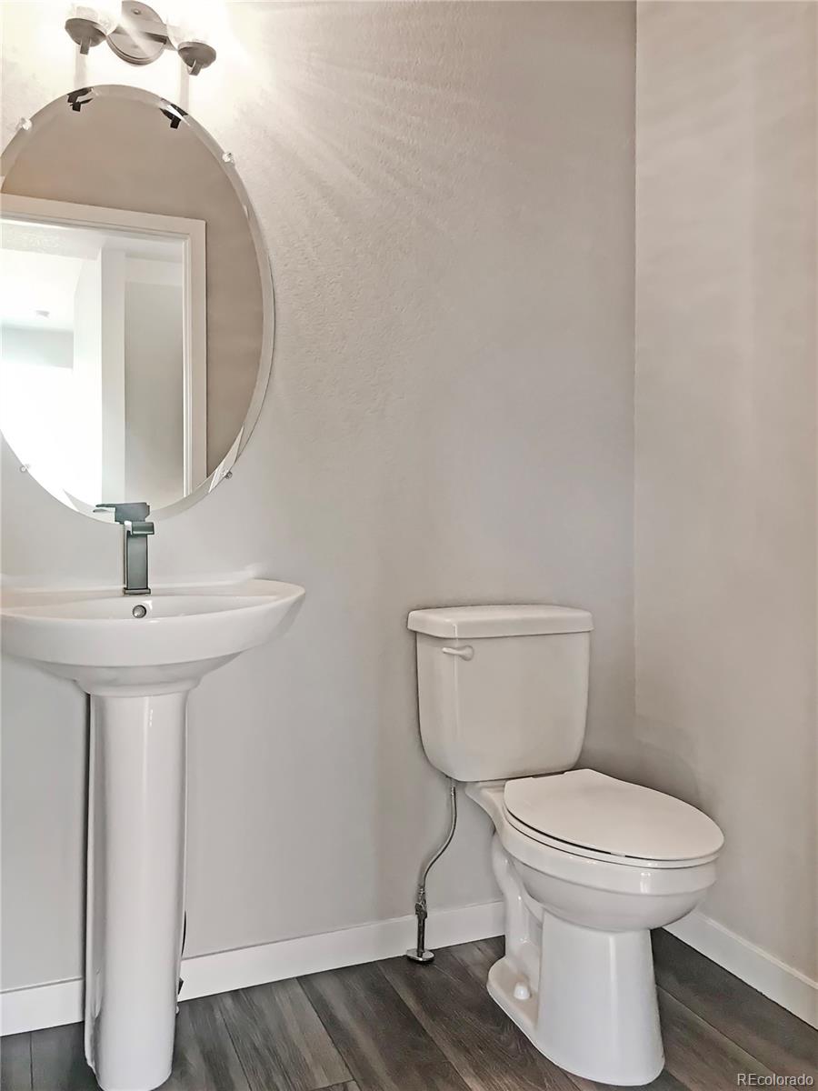 6767 South Tempe Court Aurora, CO 80016 - Photo 7 of 25 a bathroom with a toilet a sink and mirror