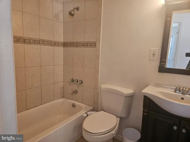 a white toilet sitting next to a bath tub