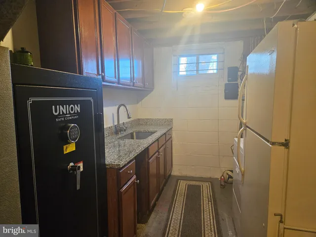a kitchen with a granite countertop refrigerator and a sink