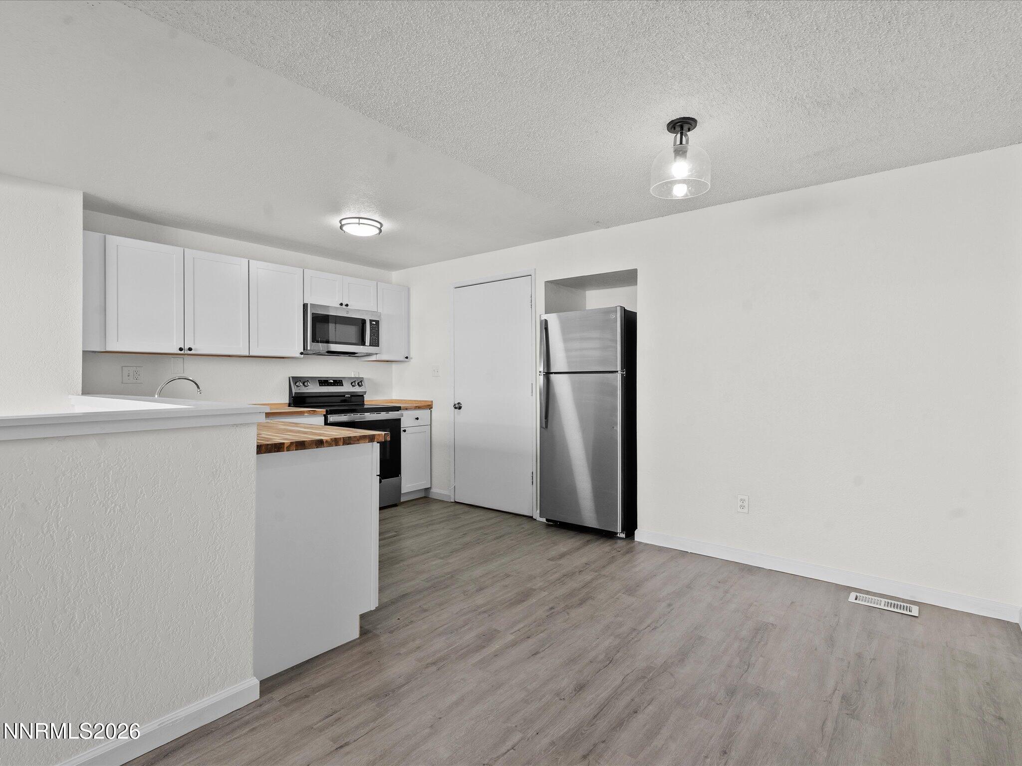 220 Allouette Way, Unit 4 Carson City, NV 89701 - Photo 7 of 22 a kitchen with wooden floors and white appliances