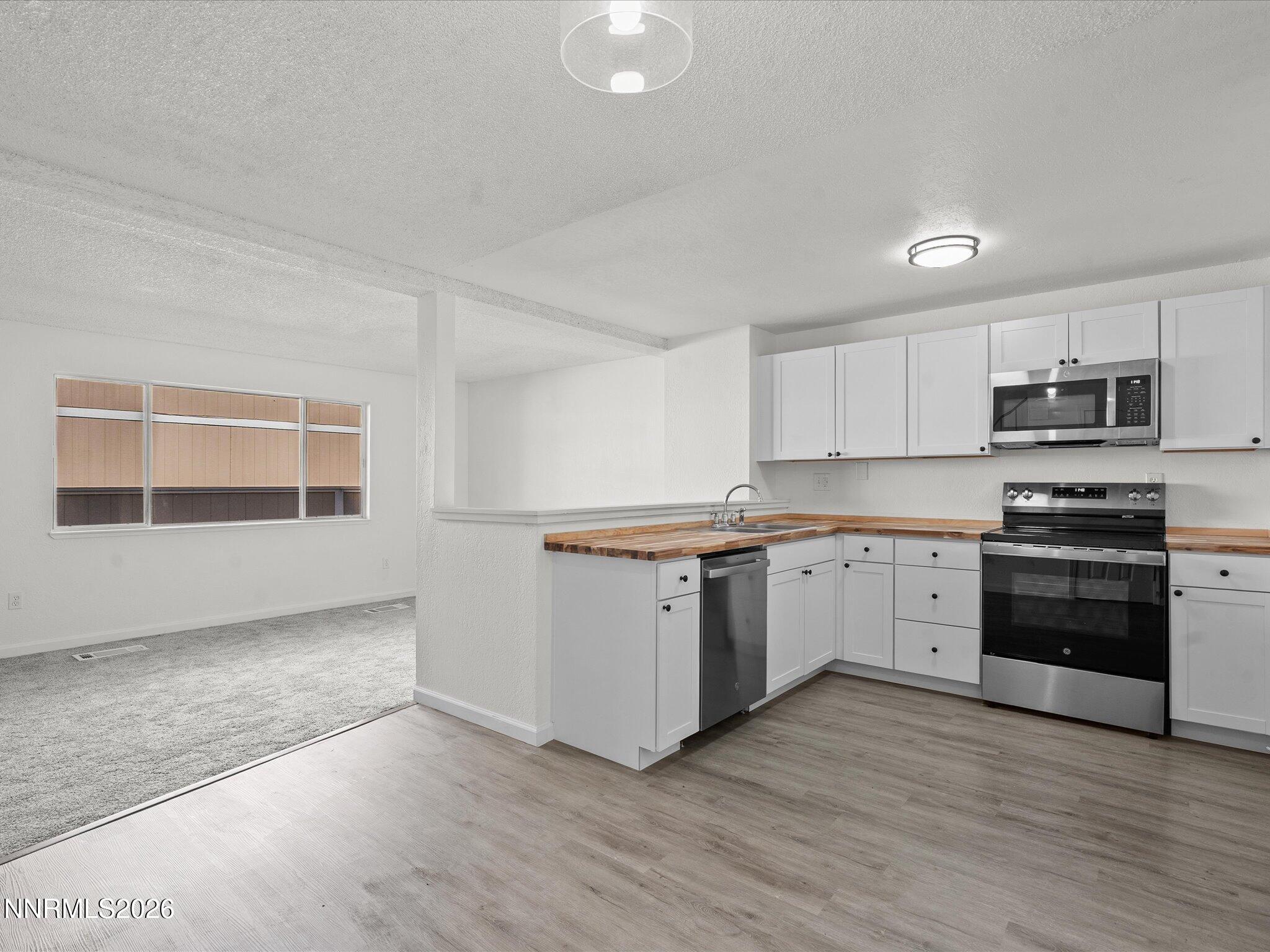 220 Allouette Way, Unit 4 Carson City, NV 89701 - Photo 10 of 22 a kitchen with granite countertop white cabinets and stainless steel appliances